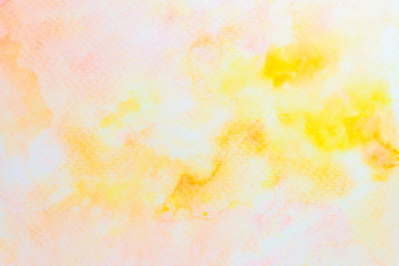 Abstract yellow and pink watercolor on paper. The color splashing in the paper. It is a hand drawn. 