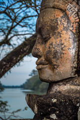 Fototapeta na wymiar Close-up of stone face with lake in the background, Angkor, Siem Reap, Combo