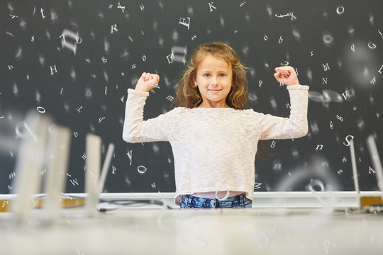 Girl In Elementary School In Front Of Blackboard With Letters