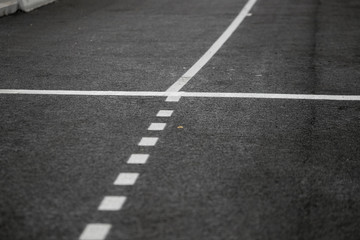 The texture of gray asphalt road. White markings on the track. Road trip. Big wide road.