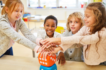 Fototapeta premium Children stack hands for integration