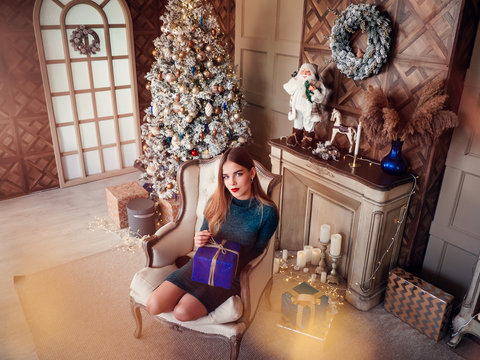 Smiling Beautiful Woman Sitting At Home Near Christmas Tree