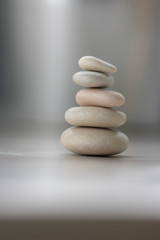Fototapeta na wymiar Harmony and balance, cairns, simple poise pebbles on wooden light white gray background, simplicity rock zen sculpture