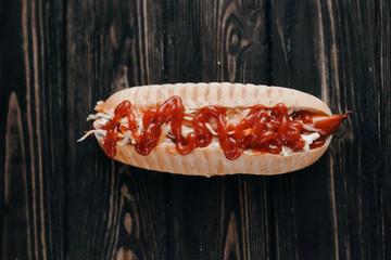 hot dog with spicy sauce on dark background.photo with copy space