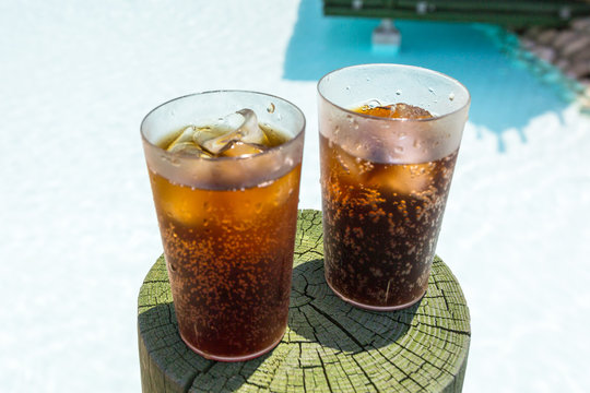 Glasses with cola and ice at the pool on summer holidays