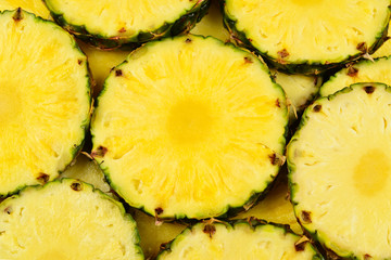 Pineapple juicy yellow slices background. Top view.