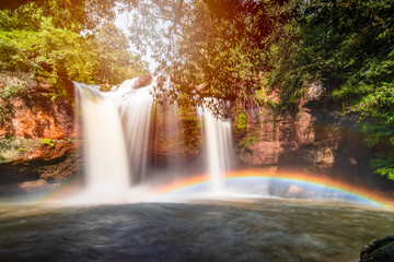 Fototapeta na wymiar Here is the paradise on the world.The waterfall and beautiful perfect rainbow.Natural will always comfort you and make you feel comfortable.Large trees help this pic feel naturally, rainy season