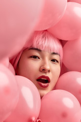 Shocked Asian female in pink balloons