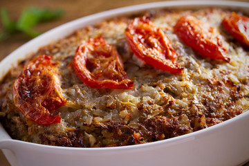Beef rice and cabbage casserole in white baking dish on wooden table