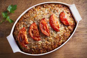 Beef rice and cabbage casserole in white baking dish on wooden table