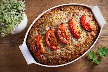 Beef rice and cabbage casserole in white baking dish on wooden table