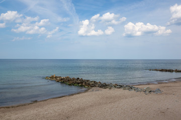 Fototapeta na wymiar Landscape with beach and breakwaters at sunny day in Niechorze, Zachodniopomorskie, Poland