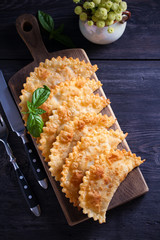 Chebureki - pan fried pies with meat and onions, served on wooden board. Fried-dough food