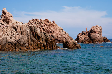 Fototapeta na wymiar Rugged rock formation at a turquoise beach at La Sorgente, Costa Paradiso in Sardinia (Italy) with turquoise blue sea