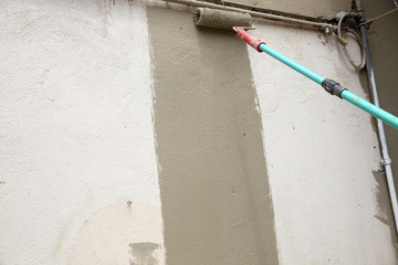 Hand painting wall with roll in dark color