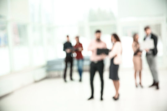 blurred image of a group of business people talking in the office lobby. photo with copy space
