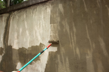 Hand painting wall with roll in dark color