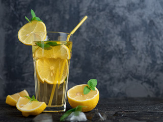 Fototapeta premium Summer lemonade Mojito with lemon and mint in glasses on a dark table