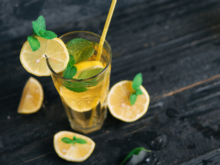Fototapeta premium Summer lemonade Mojito with lemon and mint in glasses on a dark table