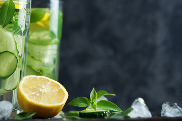 Summer cold lemonade with cucumber lemon mint Basil and ice in glasses