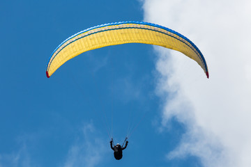 Colorful paraglider wing or canopy against blue sky with clouds