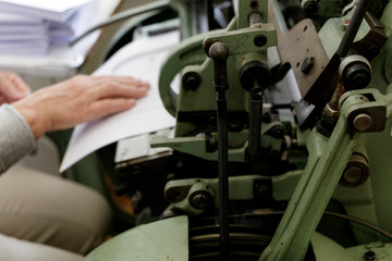Machine for stitching book pages with threads in typography.
