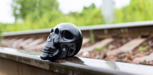 Toy skull on the rails. Railway sleepers.