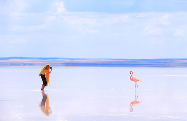 Girl taking pictures of flamingo in a salt lake Tuz Golu, Turkey