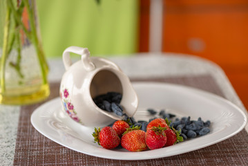 Summer arbor. The Utrenny light breakfast from berries. A honeysuckle with a wild strawberry and sour cream.