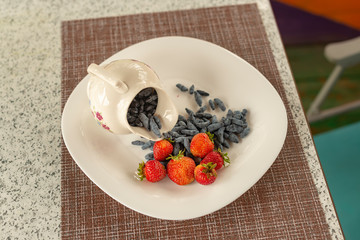 Summer arbor. The Utrenny light breakfast from berries. A honeysuckle with a wild strawberry and sour cream.