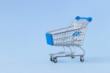 Empty shopping cart on colored background. Close-up of shopping trolley on with some copy space. Consumer concept. Online shopping concept. Black Friday and Cyber Monday 