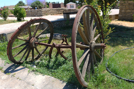 Image of an old wooden wagon wheel in the garden