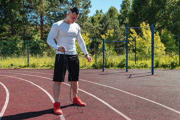 Obraz premium athletic man at the stadium with a rope. Healthy lifestyle. Sport activities on the street