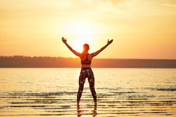 Fototapeta premium Yoga and fitness. Young woman practicing morning meditation in nature at the beach
