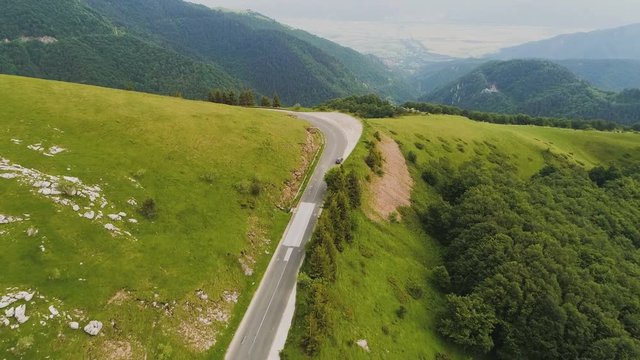 Top View Of A Car Making A Turn On A Road Situated On A Steep Mountain Hill