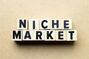 Letter block in word niche market on wood background