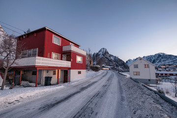 Naklejka premium Red house with snow mountain in fishing village on winter