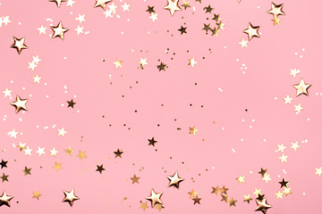 Fototapety  Golden stars glitter on pink background. Festive holiday pastel backdrop.