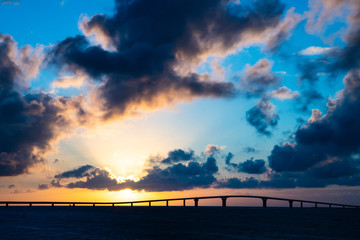 伊良部大橋にかかるサンセットの瞬間を宮古島から望む