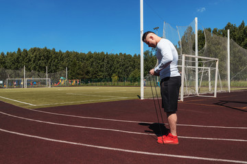 athletic man at the stadium with a rope. Healthy lifestyle. Sport activities on the street