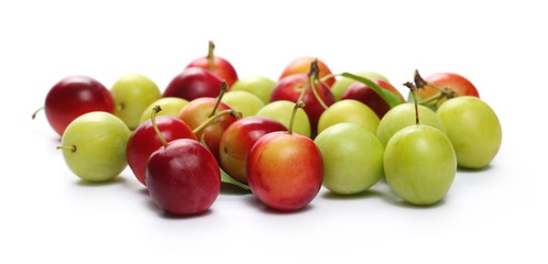 Wild yellow and red plums with leaves and twigs, isolated on white background