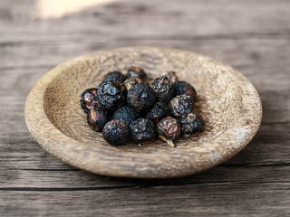 Sapindus rarak (lerak) on wood plate with wood background.