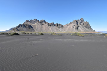Beautiful view of the Vestrahorn Mountains with black sand in front near Höfn in Iceland