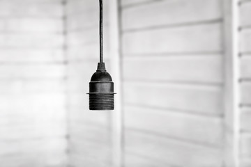 black plastic cartridge with screw thread for the bulb with the cable on a wooden light background