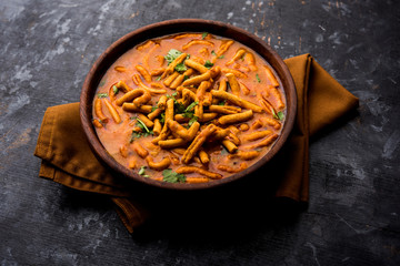 Dhaba style Sev bhaji/sabzi/curry made in tomato curry with gathiya shev, served in a bowl or karahi, selective focus