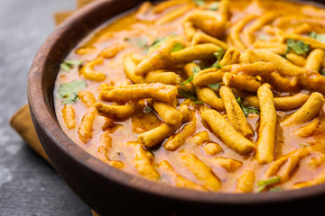 Dhaba style Sev bhaji/sabzi/curry made in tomato curry with gathiya shev, served in a bowl or karahi, selective focus