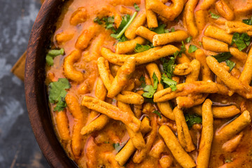 Dhaba style Sev bhaji/sabzi/curry made in tomato curry with gathiya shev, served in a bowl or karahi, selective focus
