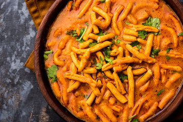 Dhaba style Sev bhaji/sabzi/curry made in tomato curry with gathiya shev, served in a bowl or...