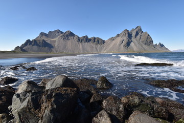 Obraz premium Beautiful view of the Vestrahorn Mountains with black sand and the ocean in front near Höfn in Iceland