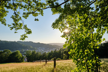 A beautiful scenic view into a rural German summer landscape in the Spessart with the town Bad Orb,...